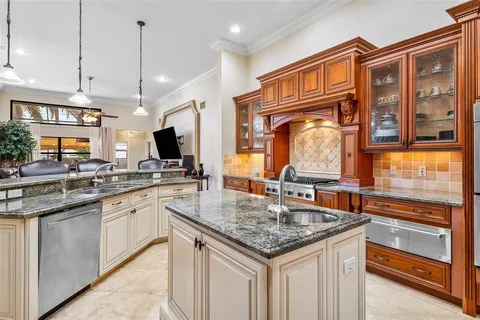 a kitchen with stainless steel appliances granite countertop a sink a stove and a refrigerator