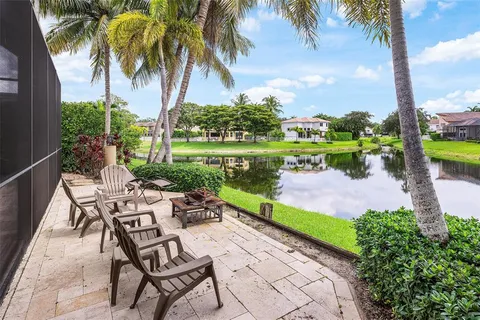 a view of a lake with a yard and large trees