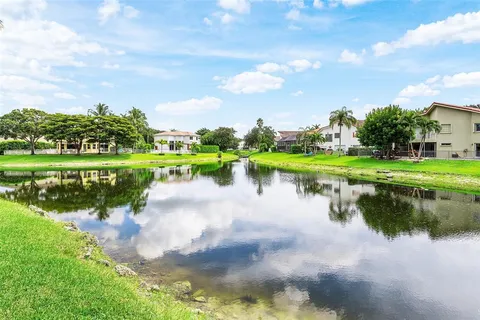 a front view of a house with garden and swimming pool