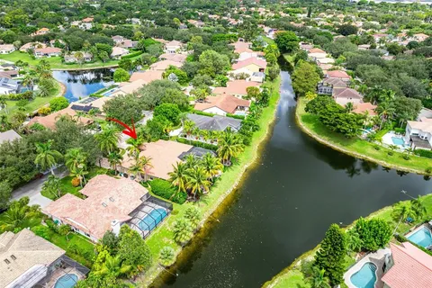an aerial view of residential houses with outdoor space and trees all around
