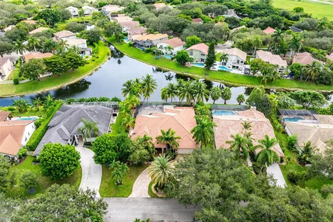 an aerial view of residential houses with outdoor space and lake view