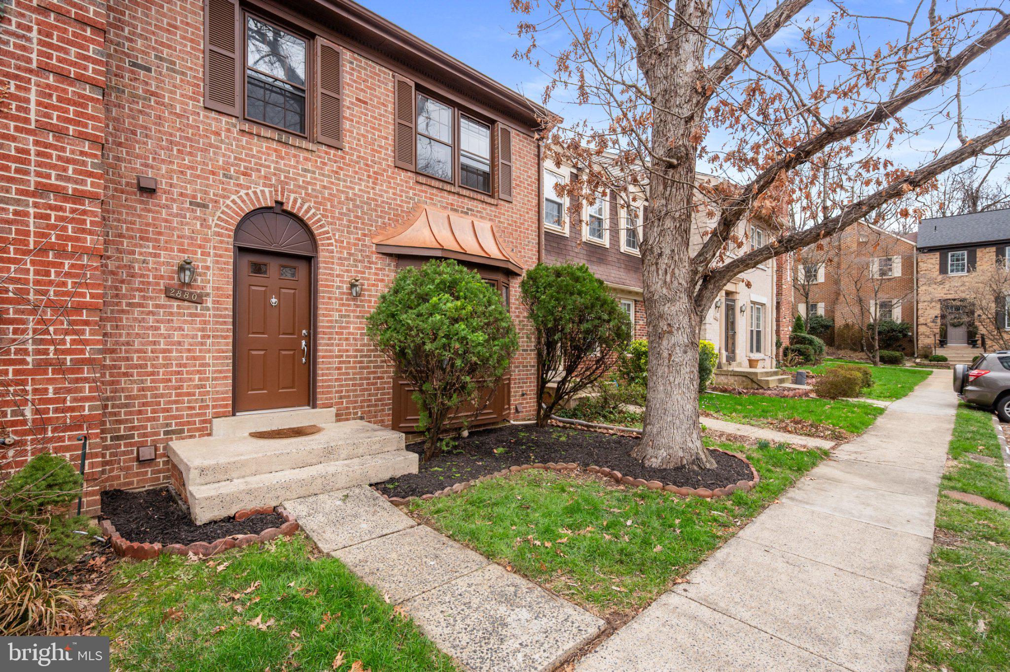 Charming brick facade with lush greenery.