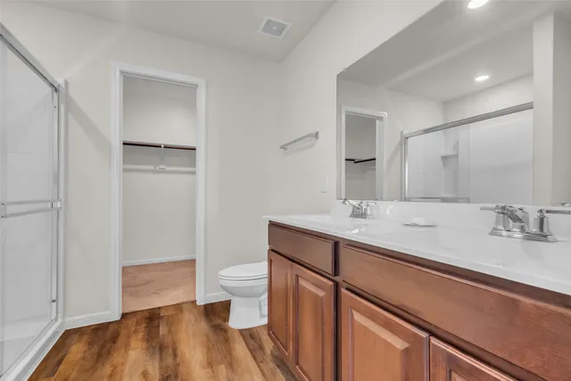 a spacious bathroom with a granite countertop sink a toilet and a mirror
