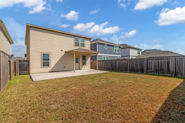a view of a house with backyard and wooden fence