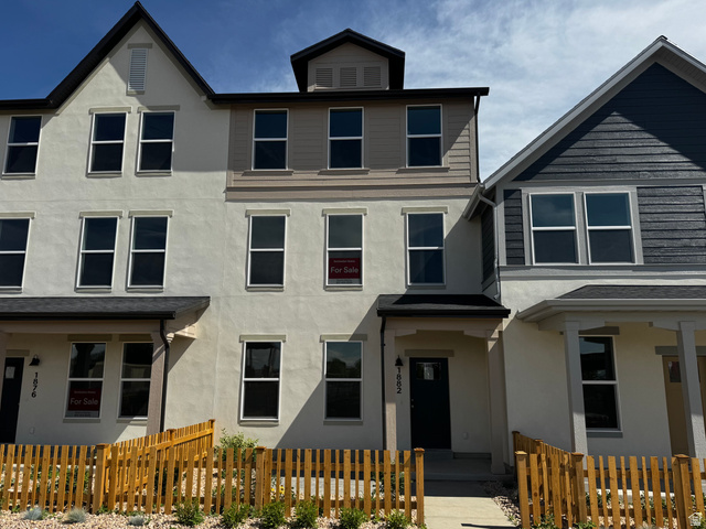 1883 West 1575th North, Unit 236 Layton, UT 84041 - Photo 1 of 22 Multi-story townhome featuring a stucco exterior, dark trim, and multiple large windows
