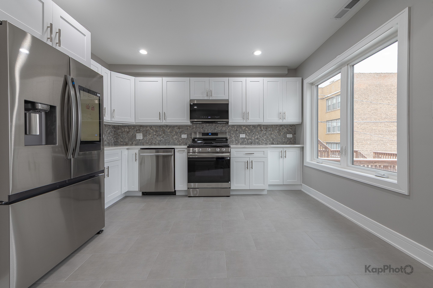 3044 West Irving Park Road, Unit 2 Chicago, IL 60618 - Photo 11 of 27 a kitchen with stainless steel appliances granite countertop a refrigerator a stove a sink and a microwave