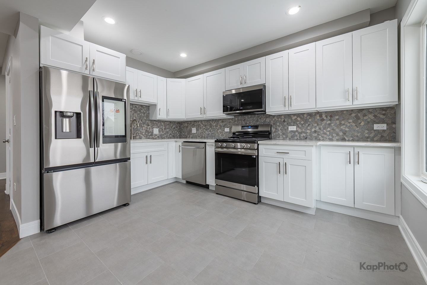 3044 West Irving Park Road, Unit 2 Chicago, IL 60618 - Photo 12 of 27 a kitchen with stainless steel appliances white cabinets and a refrigerator