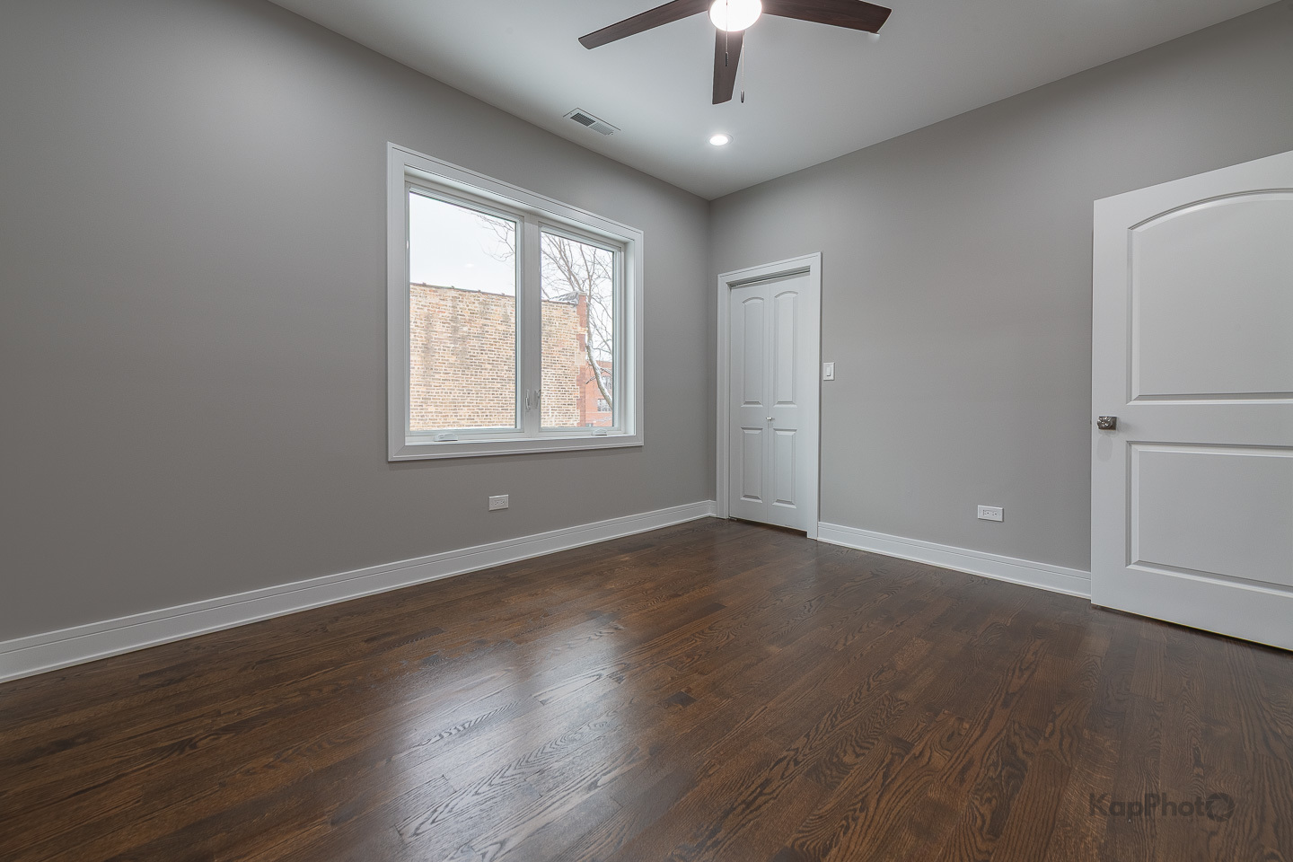 3044 West Irving Park Road, Unit 2 Chicago, IL 60618 - Photo 8 of 27 an empty room with wooden floor chandelier fan and windows