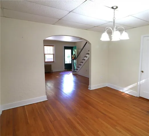 a view of a room with wooden floor chandelier and a window