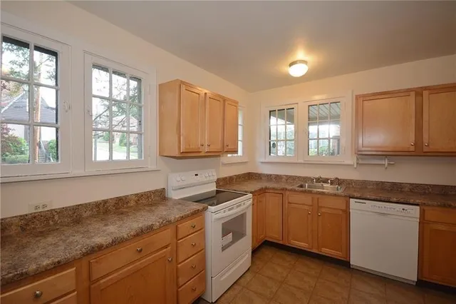 a kitchen with sink a window and cabinets