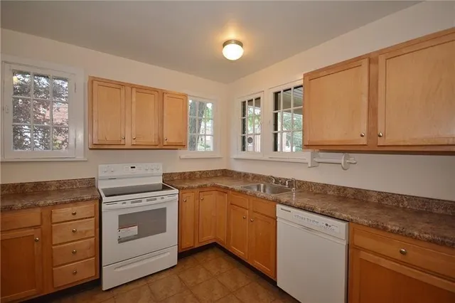 a kitchen with granite countertop white cabinets and white stainless steel appliances