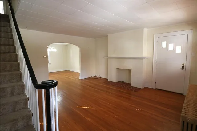 a view of empty room with stairs and wooden floor