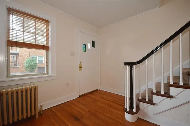 a view of front door with wooden floor and stairs