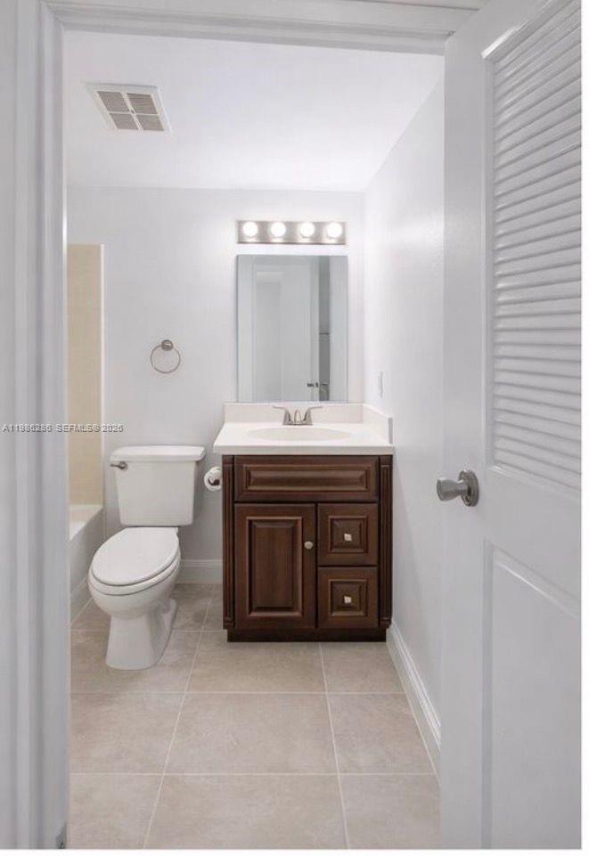 15620 Southwest 80th Street, Unit H304 Miami, FL 33193 - Photo 5 of 8 a bathroom with a sink a toilet and shower