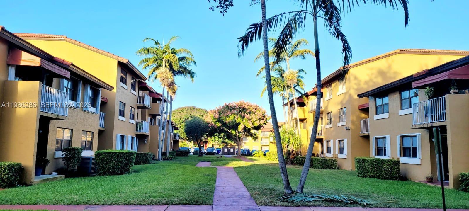 15620 Southwest 80th Street, Unit H304 Miami, FL 33193 - Photo 8 of 8 a view of a building with a yard