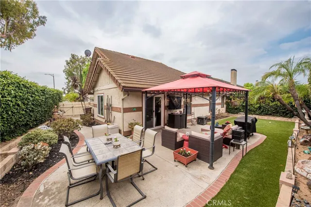 a view of a patio with table and chairs under an umbrella