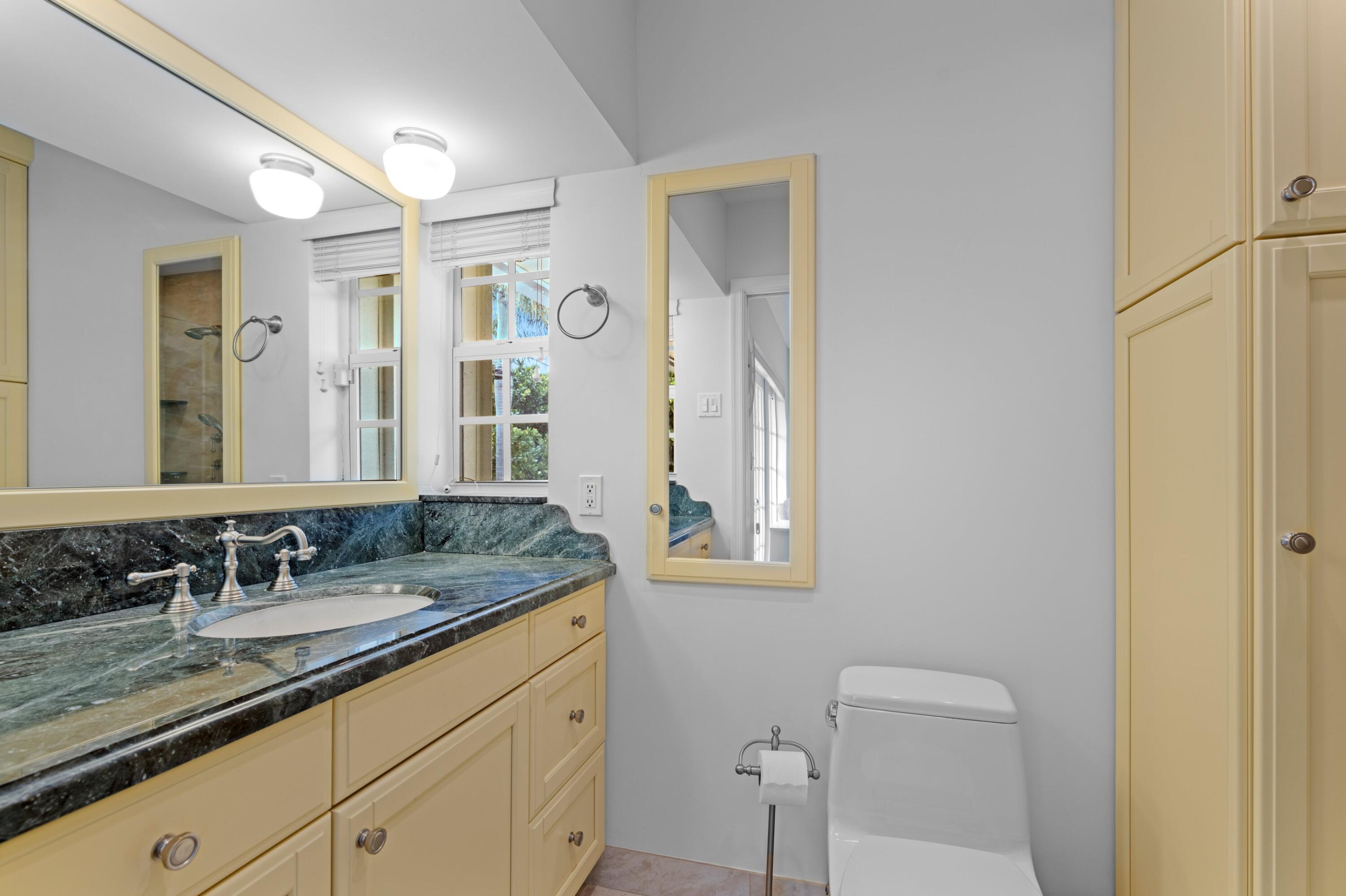 858 Hickory Terrace Boca Raton, FL 33486 - Photo 12 of 43 a bathroom with a granite countertop sink a toilet and a mirror