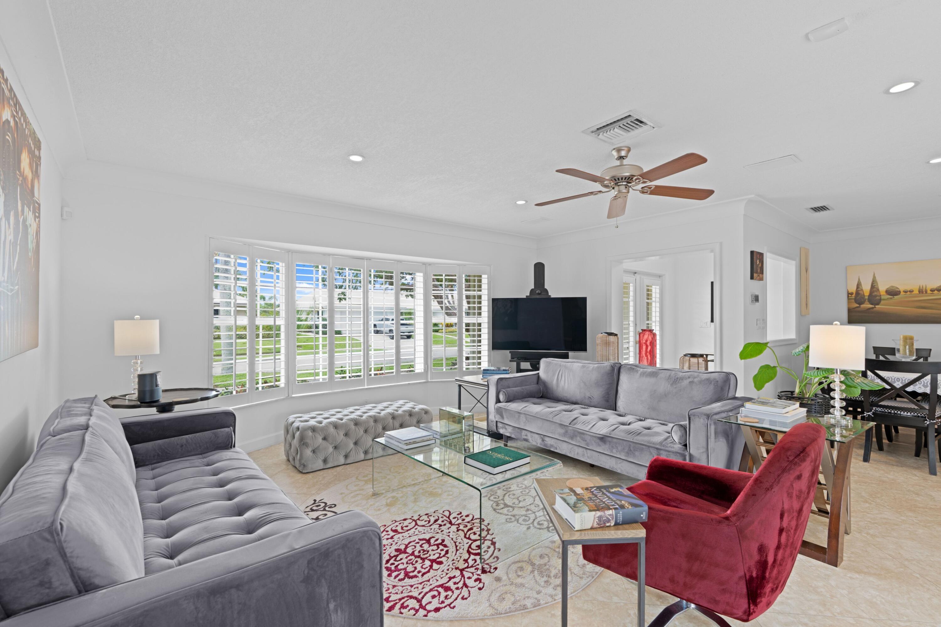 858 Hickory Terrace Boca Raton, FL 33486 - Photo 9 of 43 a living room with furniture a flat screen tv and a large window