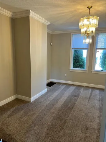 an empty room with windows and chandelier