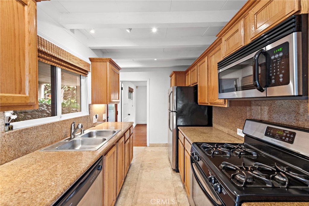 146 Cliff Drive, Unit C Laguna Beach, CA 92651 - Photo 12 of 21 a kitchen with stainless steel appliances granite countertop a stove a sink and a microwave