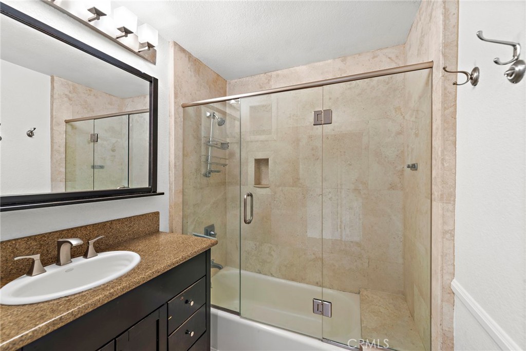 146 Cliff Drive, Unit C Laguna Beach, CA 92651 - Photo 19 of 21 a bathroom with a granite countertop shower sink and mirror