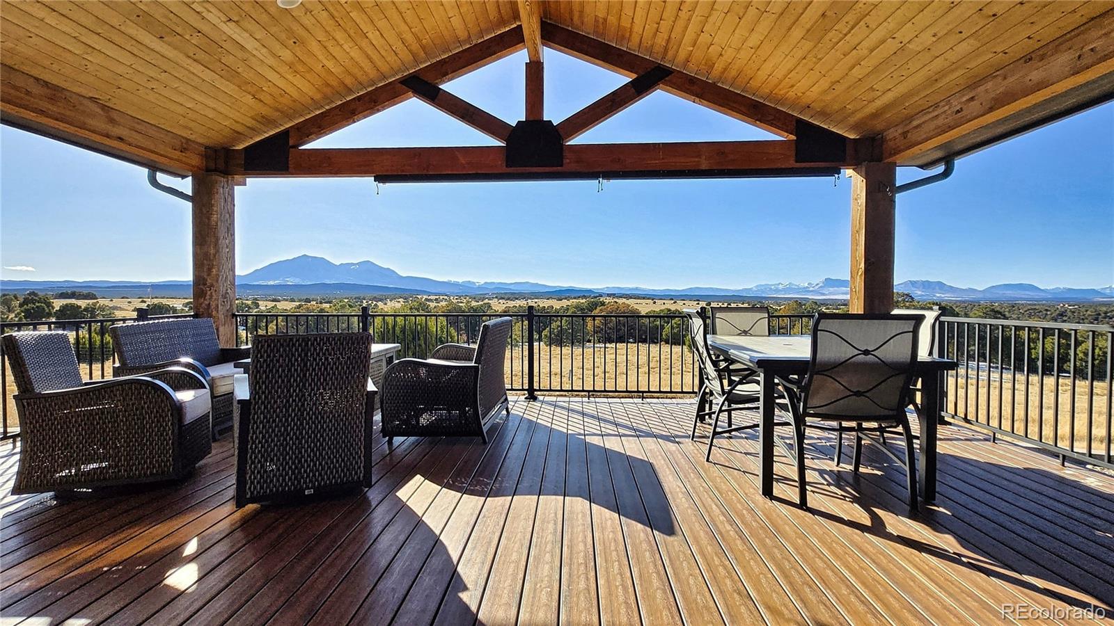 517 Trailsend Road Walsenburg, CO 81089 - Photo 2 of 33 a view of a roof deck with table and chairs under wooden roof with potted plants