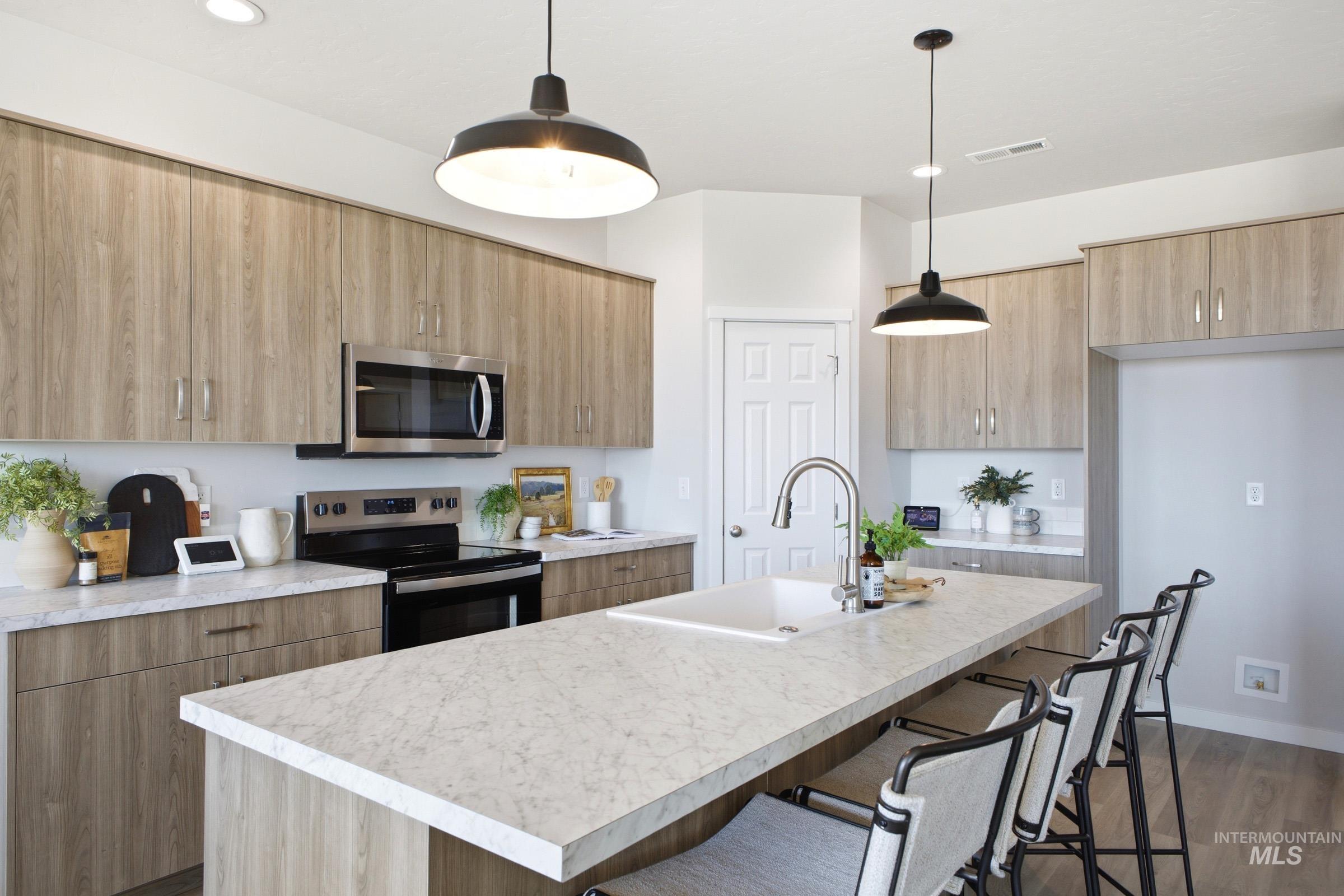 1641 Dyer Street Middleton, ID 83644 - Photo 12 of 29 Kitchen with a breakfast bar area, stainless steel appliances, a center island with sink, and light countertops