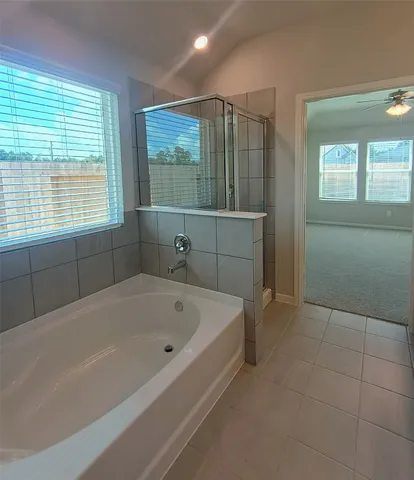 a white bath tub sitting in a bathroom next to a window