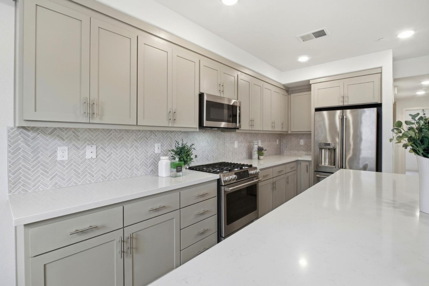 385 Line Street Hayward, CA 94544 - Photo 10 of 38 a kitchen with white cabinets and stainless steel appliances