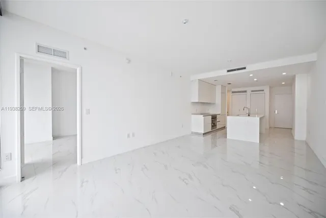 a view of a kitchen with a refrigerator and white cabinets