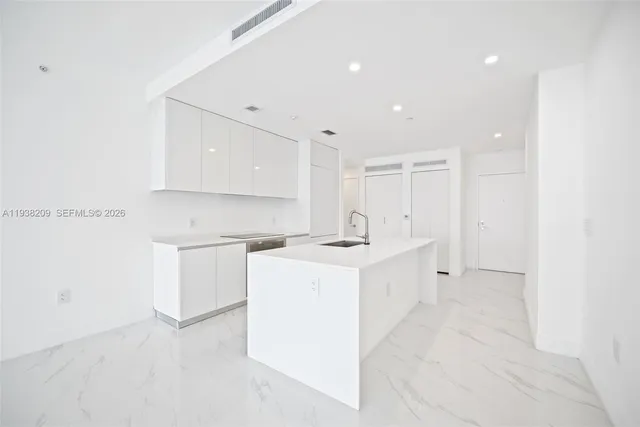 a view of a kitchen with white cabinets