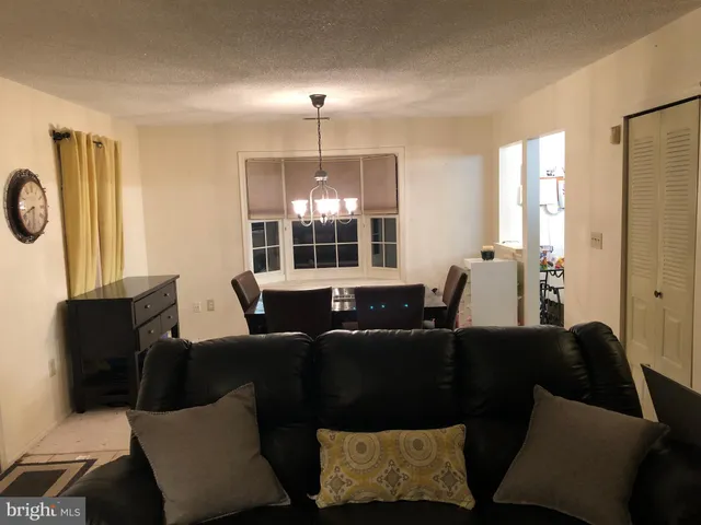 a living room with furniture a lamp and a large window