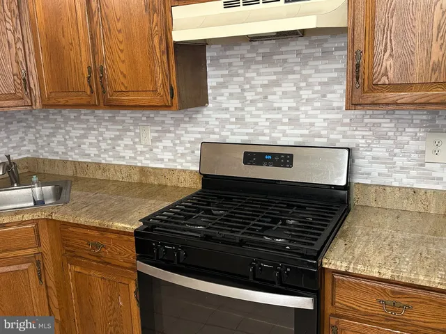a stove top oven sitting inside of a kitchen