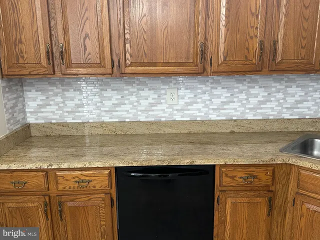a view of kitchen with granite countertop cabinets