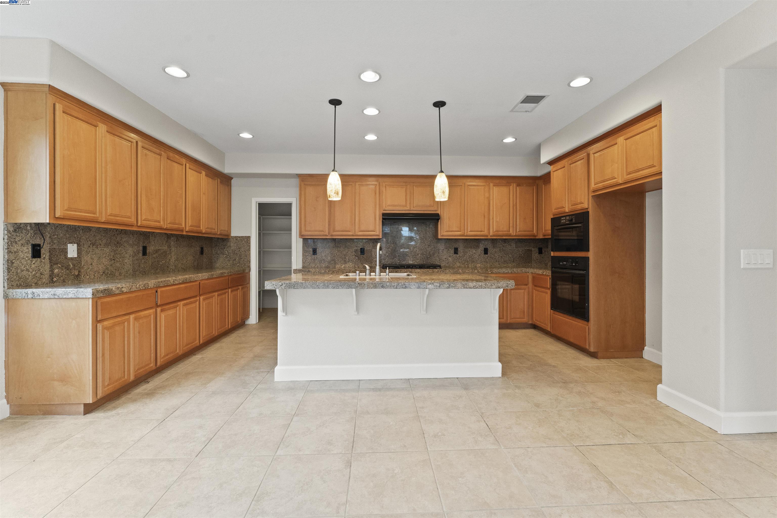 204 Daylilly Lane Patterson, CA 95363 - Photo 15 of 52 a large kitchen with a large counter top stainless steel appliances and cabinets