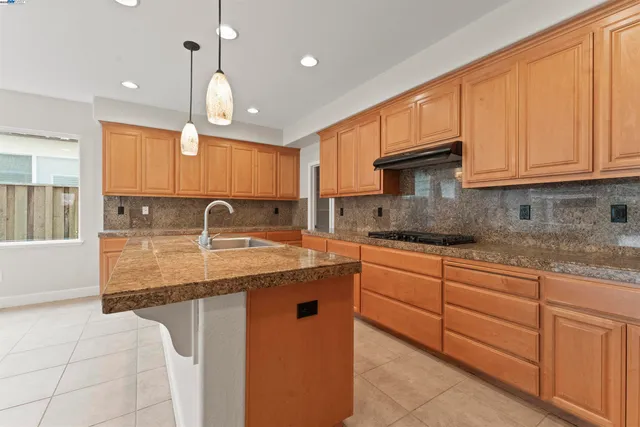 a kitchen with stainless steel appliances granite countertop a sink a stove and a microwave oven