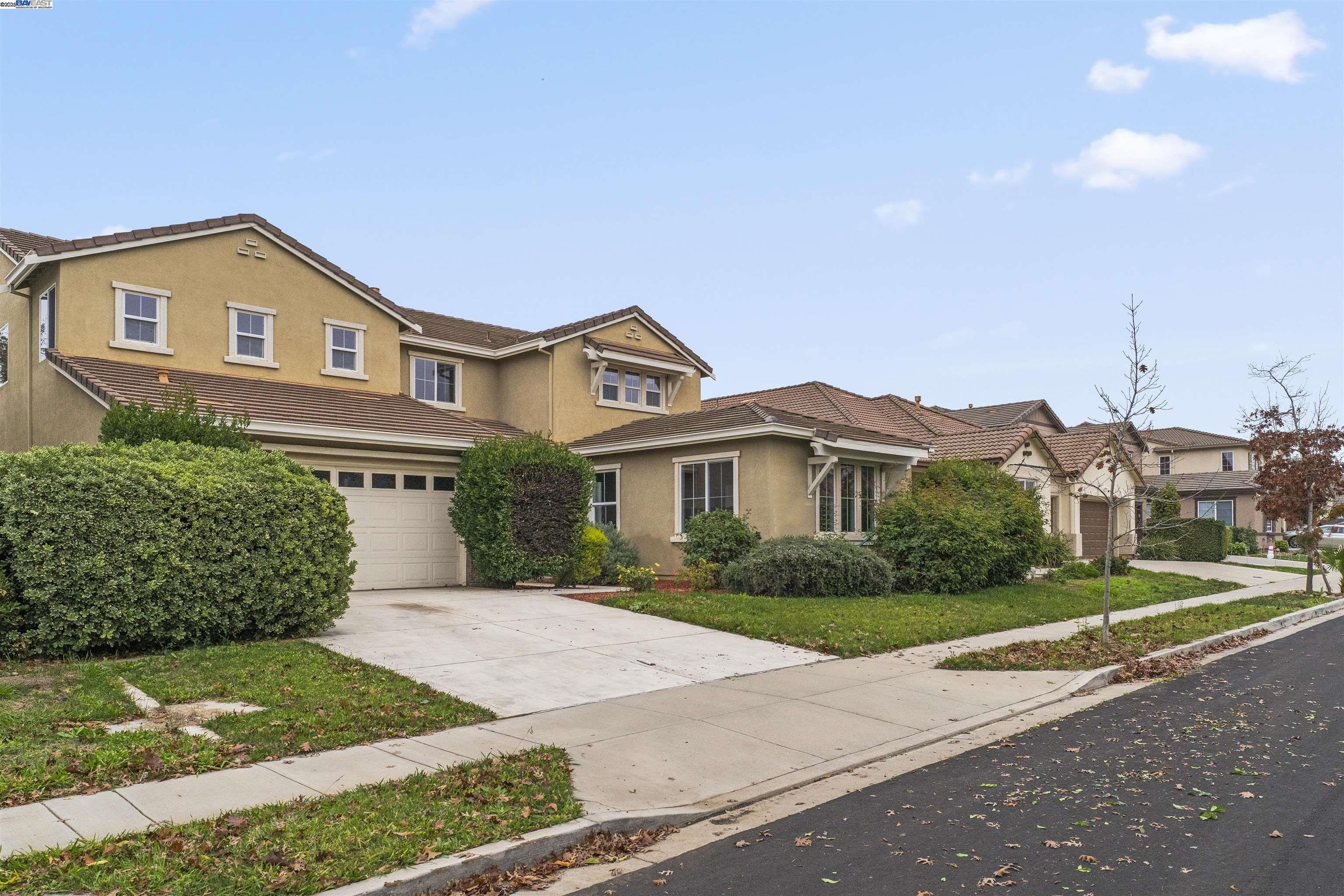 204 Daylilly Lane Patterson, CA 95363 - Photo 2 of 52 a front view of a house with a yard and garage