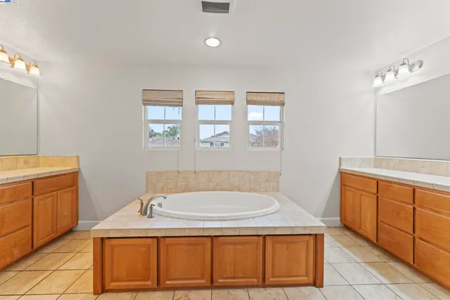 a spacious bathroom with a granite countertop tub sink and mirror