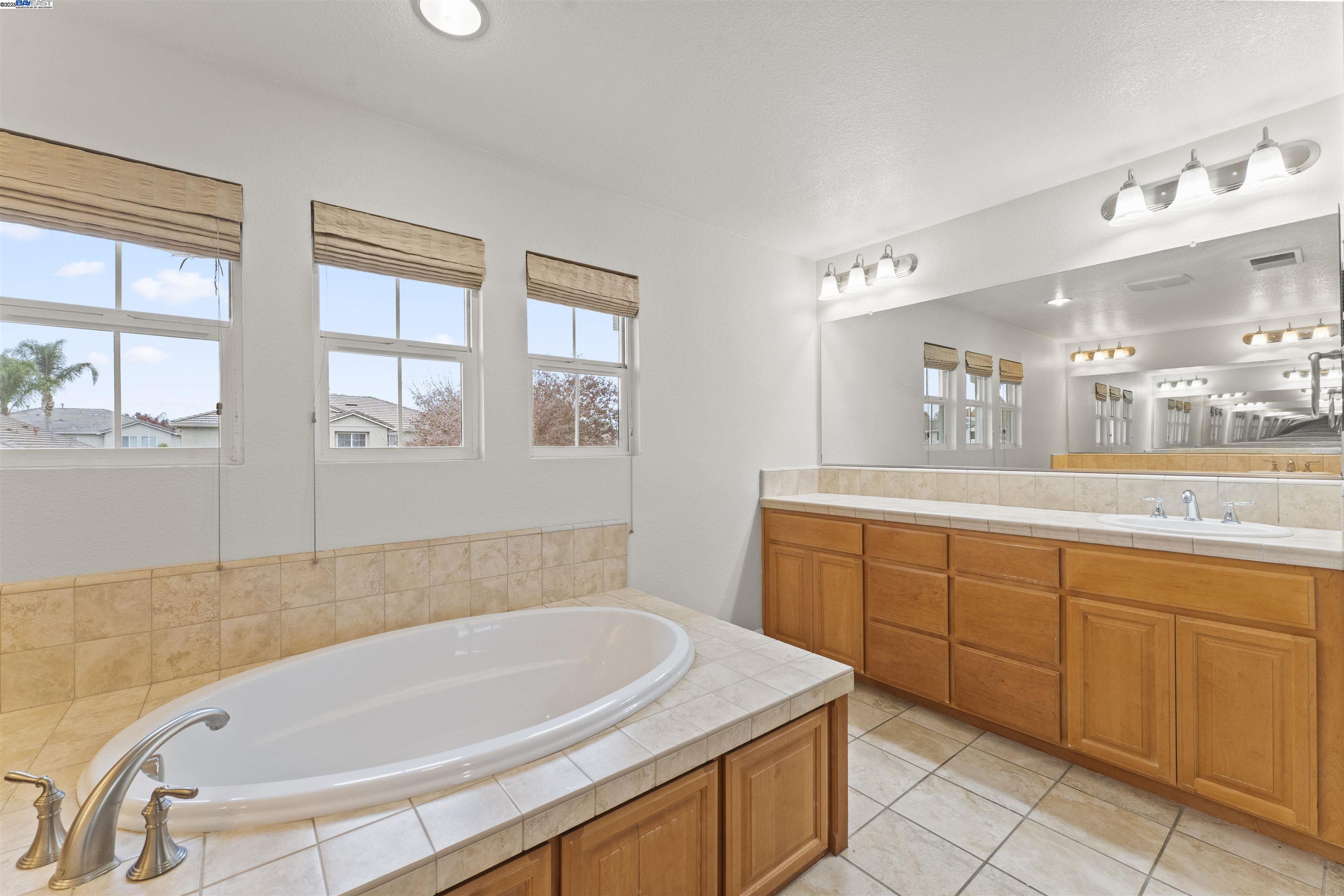 204 Daylilly Lane Patterson, CA 95363 - Photo 39 of 52 a spacious bathroom with a granite countertop tub sink and mirror
