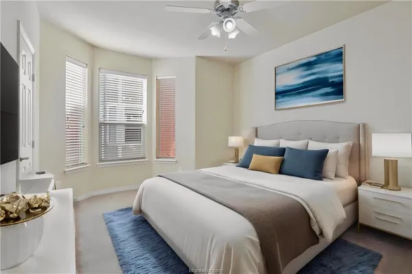 an empty room with a chandelier fan and windows