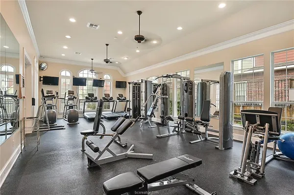 a room with furniture pool table flat screen tv and windows
