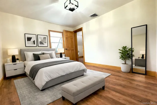 a bedroom with a large bed and a potted plant