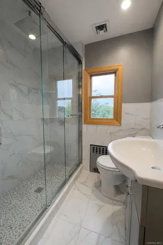 a bathroom with a sink a toilet and shower