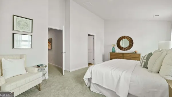 a bedroom with a bed and painting on the wall