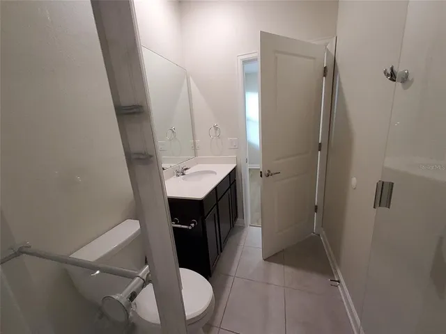 a bathroom with a sink a toilet a shower a mirror and vanity