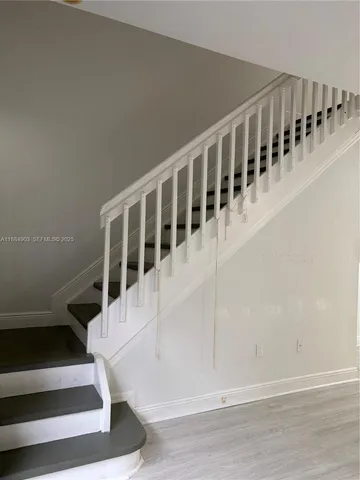 a view of staircase with white walls and a window