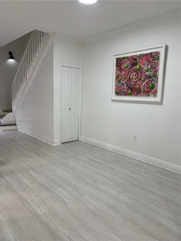 a view of a room with wooden floor and entryway