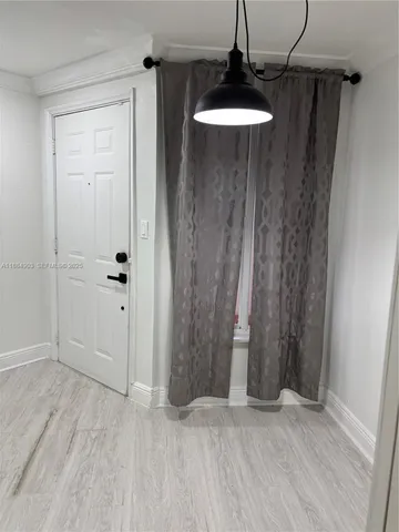 a view of a room with wooden floor and cabinet