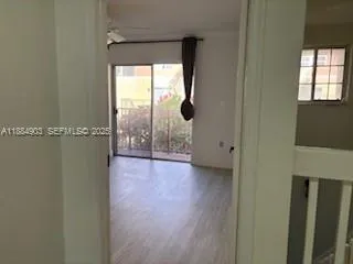 a view of a room has wooden floor and a window