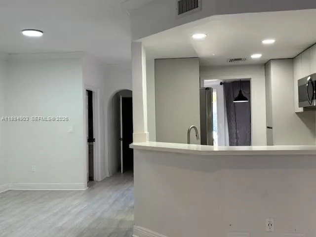 a kitchen with stainless steel appliances a microwave a stove and white cabinets